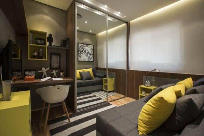 quarto um pouco mais moderno que utilizou cinza, amarelo e branco compondo um quarto muito bonito e bem decorado, utilizando almofadas, quadros e tapetes para compor o ambiente.