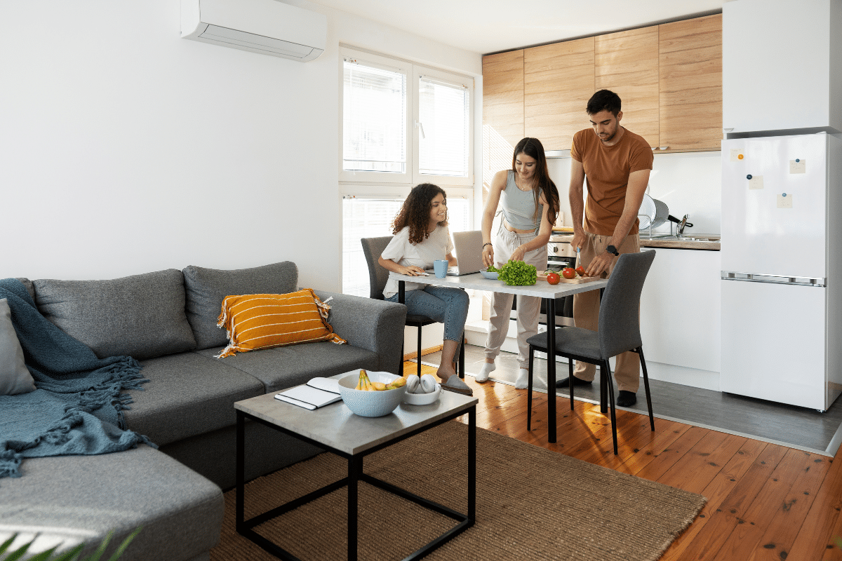 grupo de amigos reunidos em sala e cozinha integradas de uma casa.