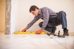 Homem fazendo instalação após descobrir como escolher porcelanato.