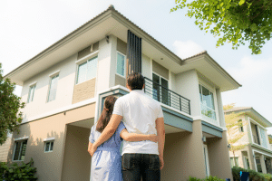 Casal olhando para casa após descobrir como construir um sobrado.