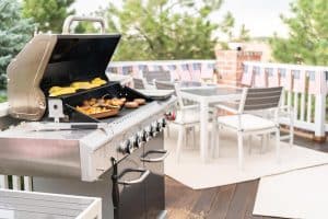 uma área de churrasco no terraço toda planejada com móveis.