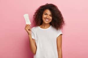 Mulher feliz ao conseguir Absorventes gratuitos pelo SUS.