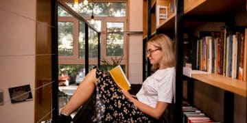 Mulher lendo ao descobrir Como criar um cantinho da leitura e fazer um espaço com estantes em casa.