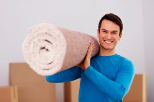 Homem feliz carregando tapeçaria para decoração. 