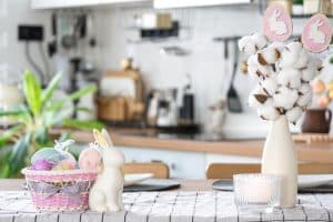 Bancada com decoração de Páscoa, mostrando coelhos e ovos enfeitados.