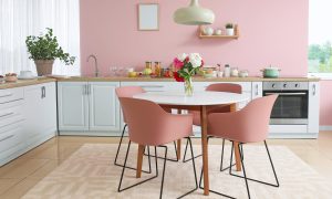 Cozinha colorida com paredes e cadeiras rosas. 