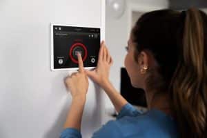 Mulher utilizando a tecnologia residencial para segurança própria.