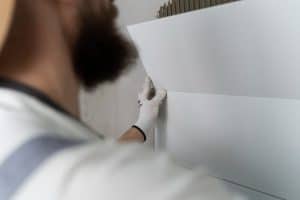 pessoa instalando revestimento de parede