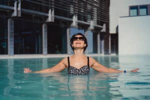 mulher aproveitando piscina de vidro.