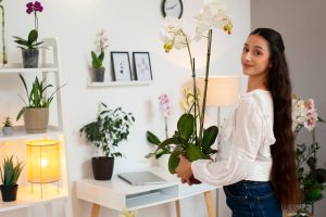 mulher escolhendo orquídeas como plantas para apartamento.