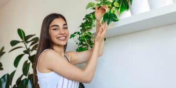 Mulher feliz com plantas para apartamento.