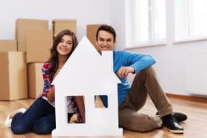 Young couple with house sign