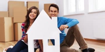 young couple with house sign