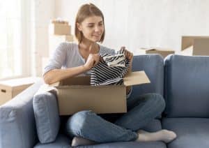 woman-packing-box-with-clothes-move-house
