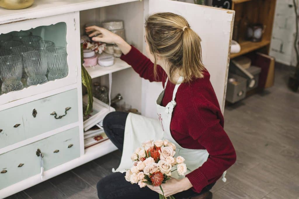 Decoração sustentável com móveis usados: transforme sua casa 2 Pessoa escolhendo objetos decorativos e avaliando diferentes opções para a casa.