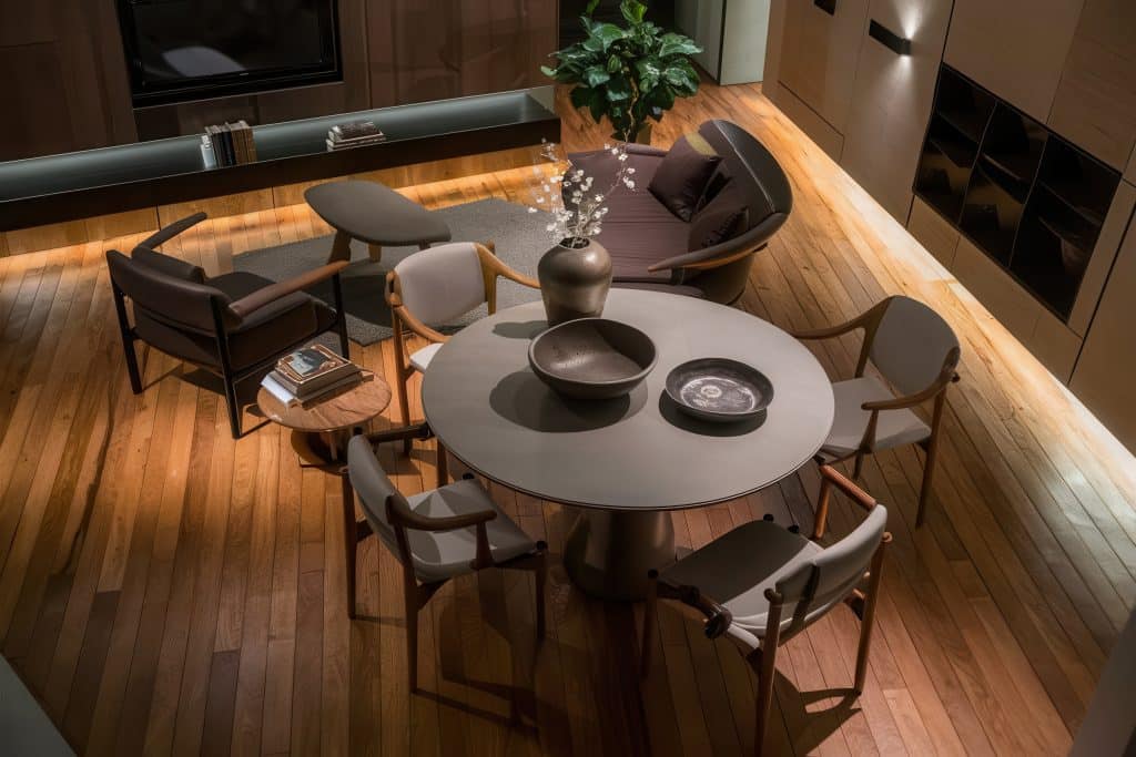 Madeira escura na decoração: tendências para 2026 1 Sala contemporânea decorada com mesa e elementos em madeira escura.